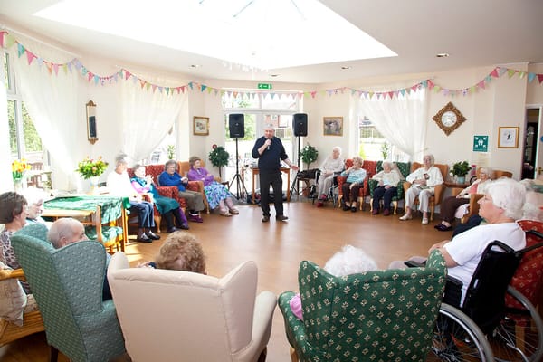 Residents enjoying an entertainment session with a performer