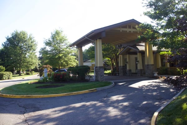 The entrance of Sunrise at Bon Air with covered drop-off area and greenery.