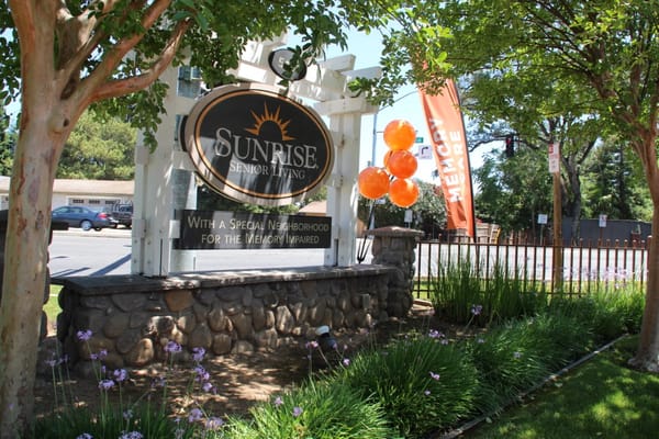 Signage for Sunrise Senior Living with balloons in front