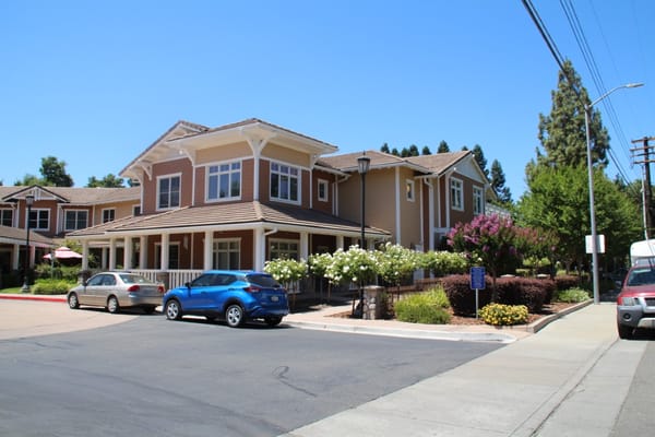 Exterior of Sunrise of Carmichael with landscaped entrance and parked cars