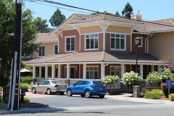 Exterior of Sunrise of Carmichael senior living facility with parked cars and landscaped gardens.