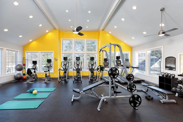 Interior view of the gym with exercise equipment and mats.