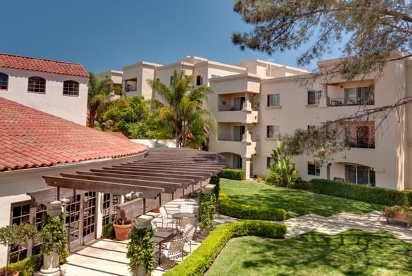 Outdoor common area featuring a pergola and lush landscaping