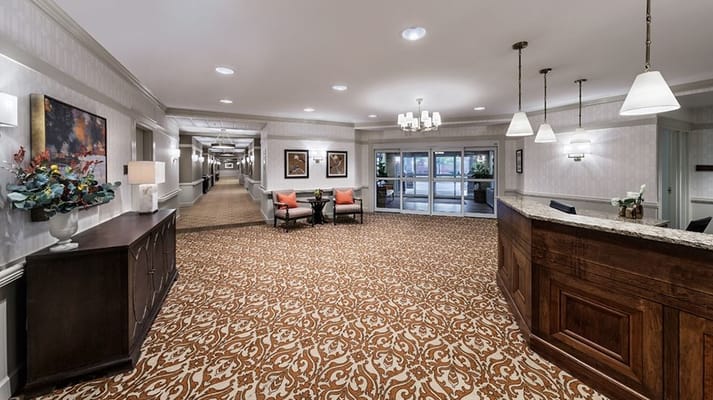 Spacious lobby with a reception desk, seating area, and decorative accents.