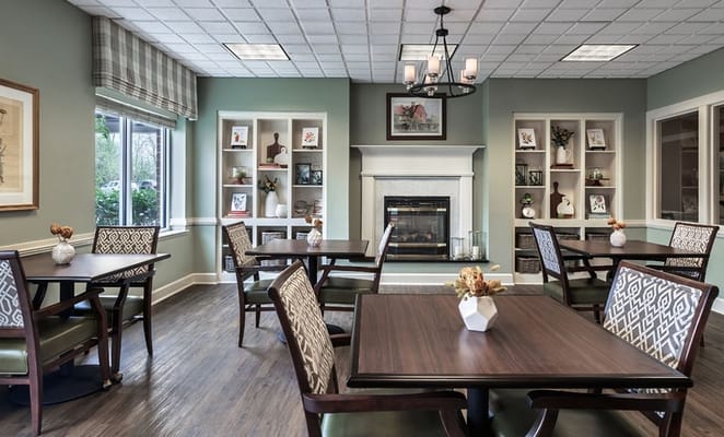 Cozy common area with tables and chairs near a fireplace