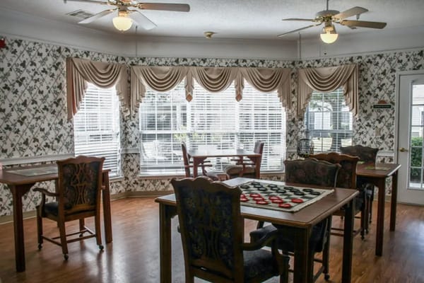 Indoor common area with tables and chairs at Lakes at Gainesville Assisted Living.