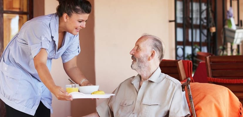 Staff member serving food to a resident outdoors