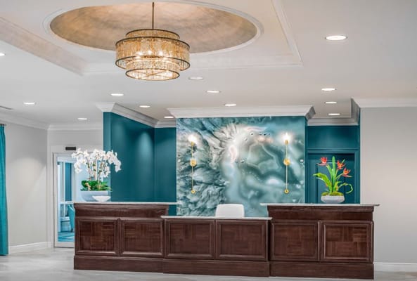 Modern reception desk with a chandelier and decorative plants