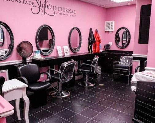 Interior view of the salon with pink walls and mirrors
