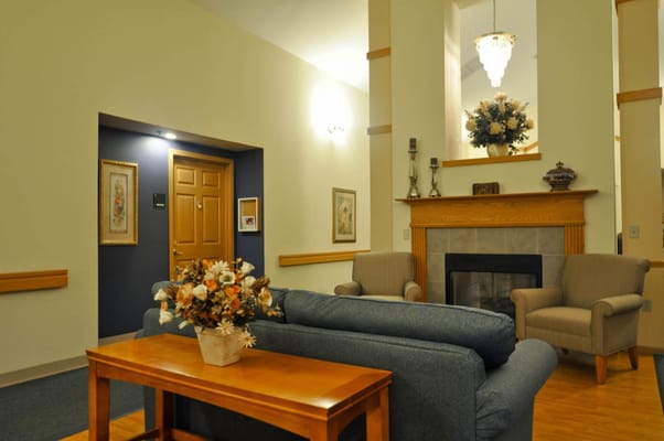 Comfortable living room area with a sofa, armchairs, and decorative flowers.