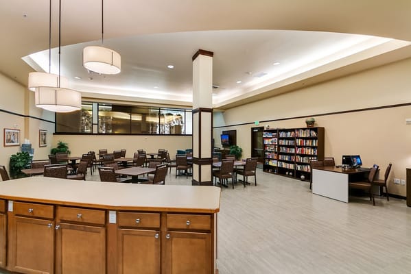 Interior common area with tables, chairs, and bookshelves