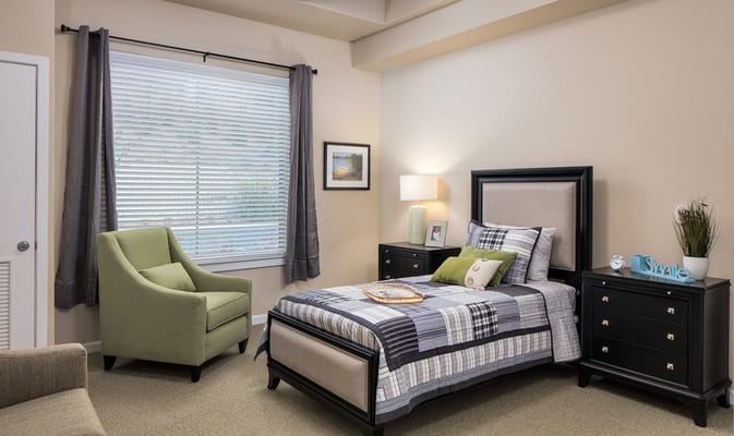 Cozy private resident room with a bed and chair