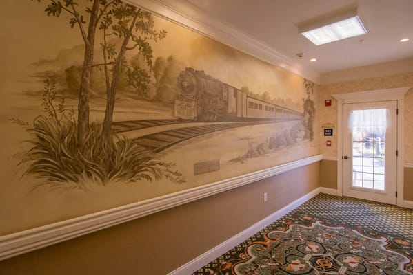 Interior mural of a train scene in a hallway