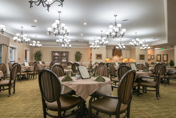 Elegant dining room set for a meal with chandeliers.
