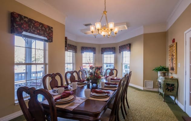 A dining room set up for a meal with large windows