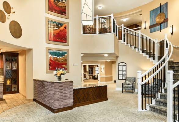 Bright interior lobby with artwork and a staircase
