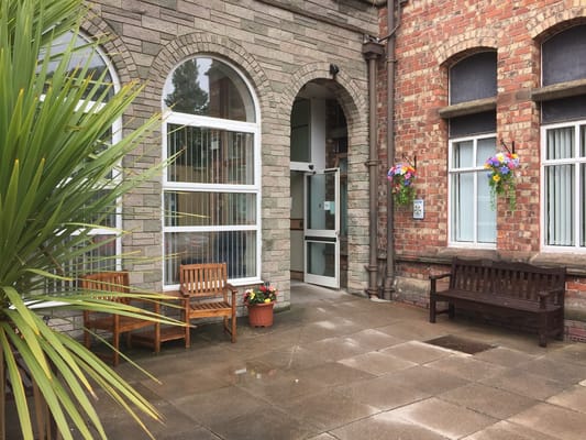 Welcoming entrance to assisted living facility with benches