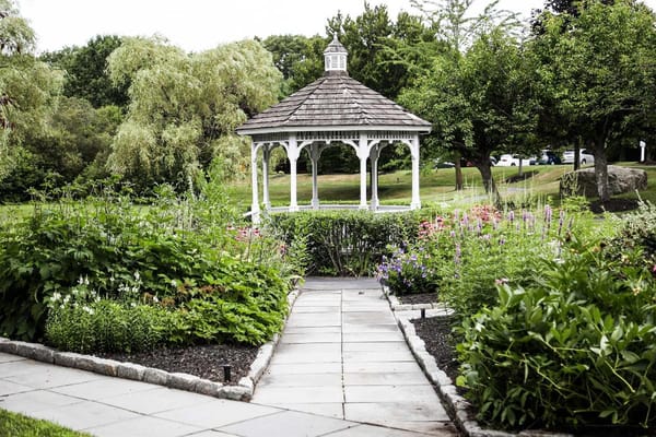 Gazebo surrounded by vibrant flowers and greenery