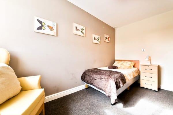 Cozy resident room with a bed and artwork on the wall