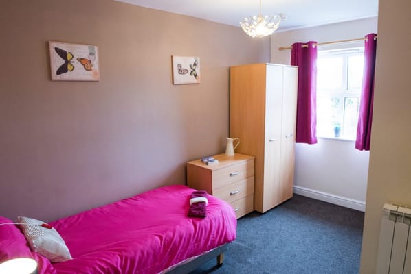 Cozy resident room with pink bedding and furniture