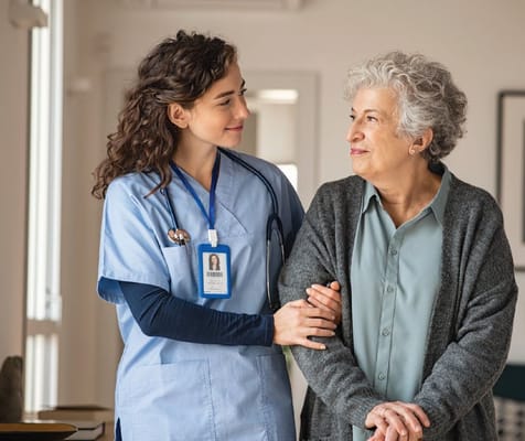 A caregiver and a senior resident engaging in a friendly conversation.