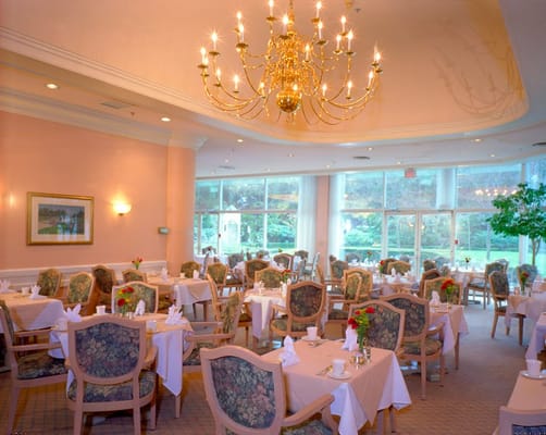 Elegant dining room with chandeliers and floral centerpieces