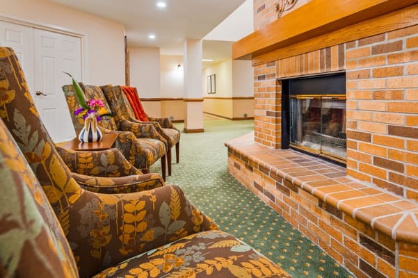 Lounge chairs near a fireplace in a senior living facility
