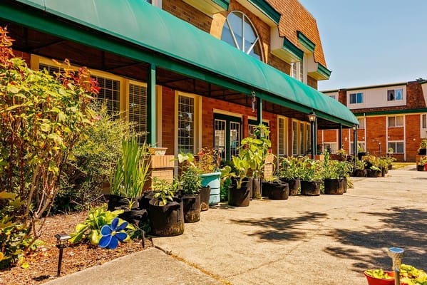 Entrance of Peoples Senior Living with flower beds and plants.