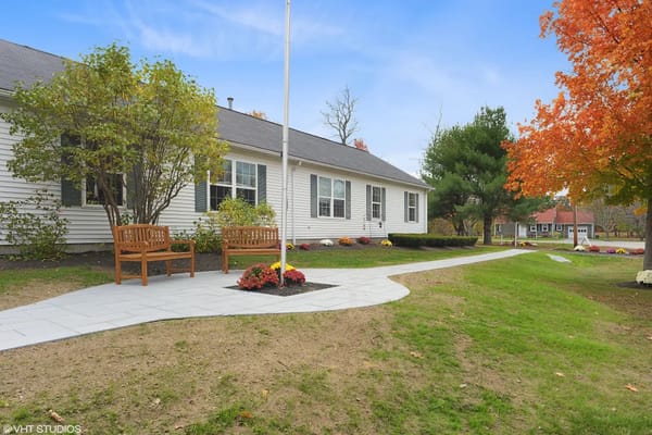 Scenic outdoor seating area with benches and autumn foliage.