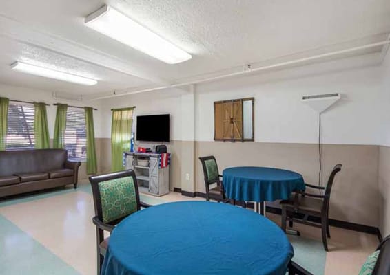 Spacious common room with blue tables and a sofa