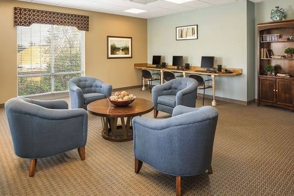 Common area with blue chairs and computer stations