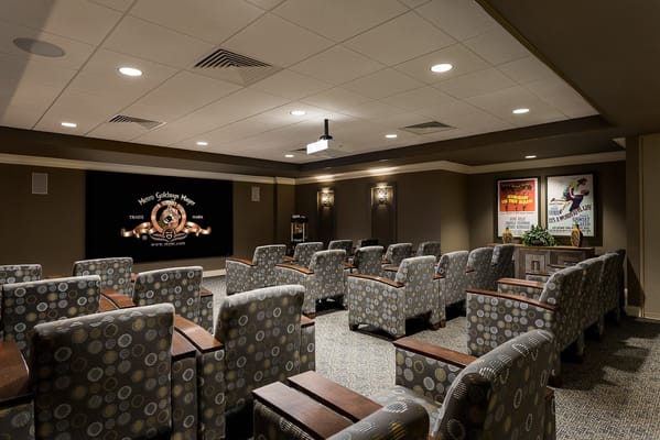 Interior view of the theater room with seating and projector screen