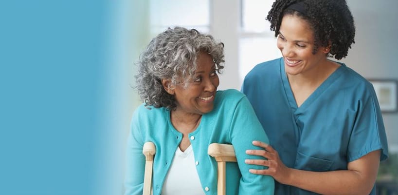 A caregiver smiling with a resident in a facility