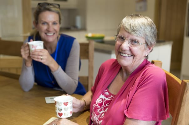 Two residents enjoying tea together in a dining area