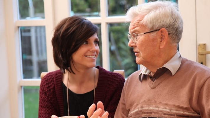 A woman and elderly man engaged in conversation