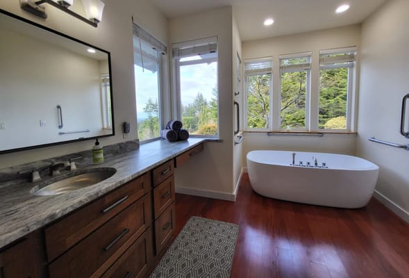 Bright bathroom featuring a freestanding tub and large windows