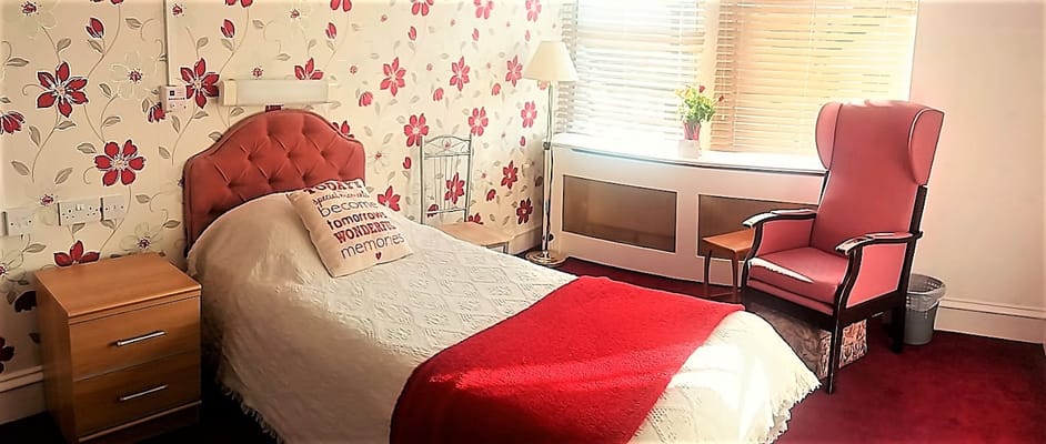 Cozy resident room with floral wallpaper and seating