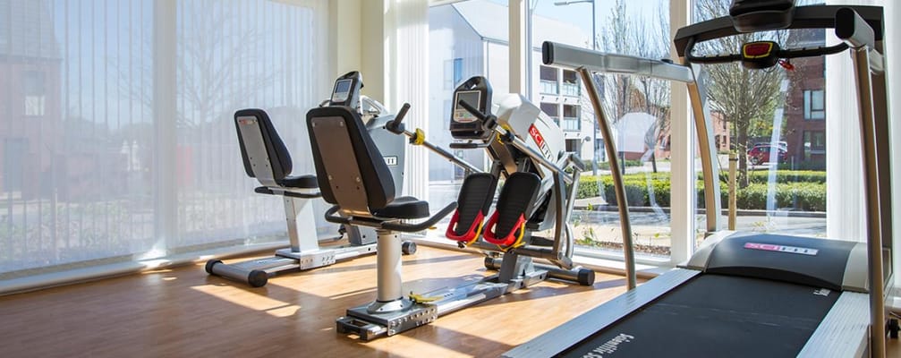 A well-lit fitness room with exercise equipment