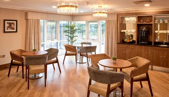Bright lounge area with tables and chairs at Saxon Manor Care Home.