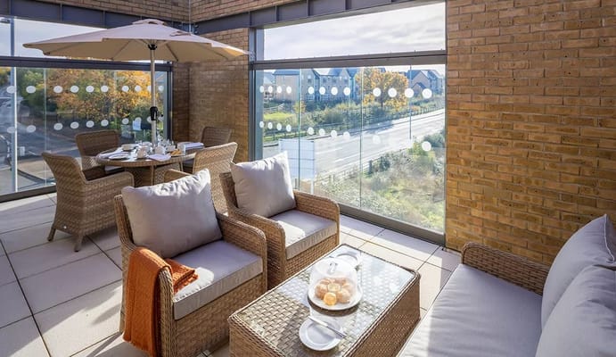 A cozy patio with seating and a table, featuring a view of the outdoor scenery.