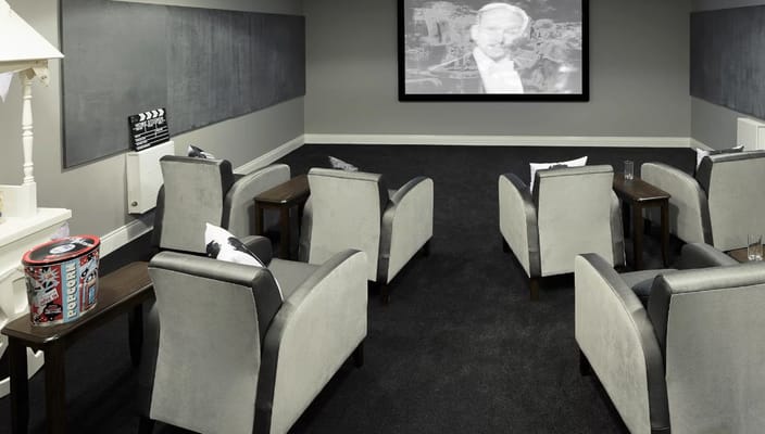 Comfortable seating in the theatre room with a movie screen
