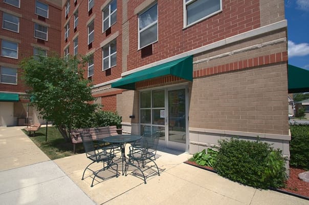 Seating area with a table and chairs outside the Senior Suites Jefferson Park