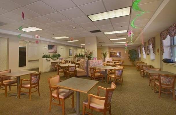 Spacious dining area with tables and chairs in a senior living facility