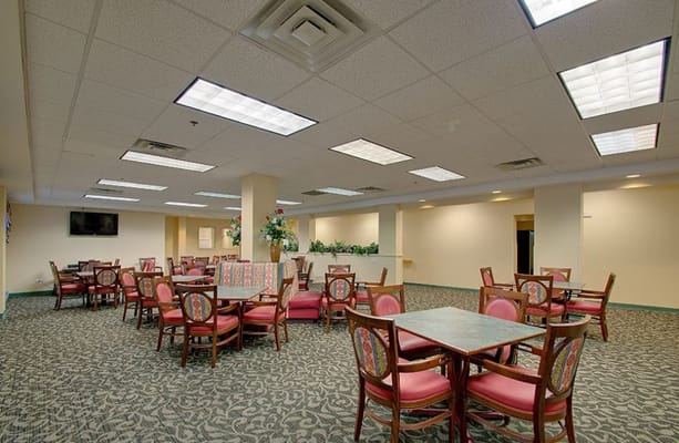 Spacious dining area with tables and chairs in a senior living facility