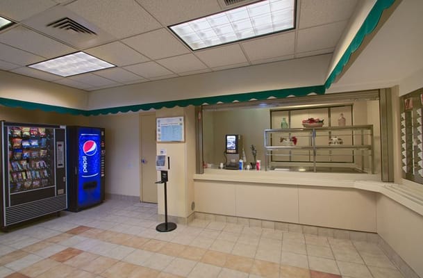 Interior view of the reception area featuring vending machines and a service counter.
