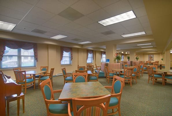 Spacious common area with tables and chairs at Senior Suites of Chatham