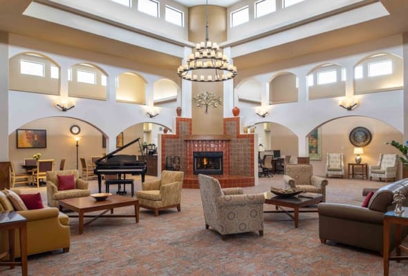 Spacious lounge with seating, a piano, and a fireplace at Silver Springs.