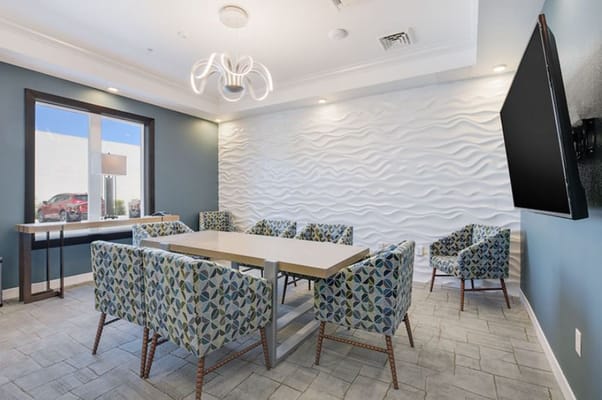 A modern lounge area with patterned chairs and a light fixture.