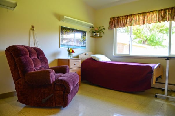 Patient room with a bed, recliner, and window.
