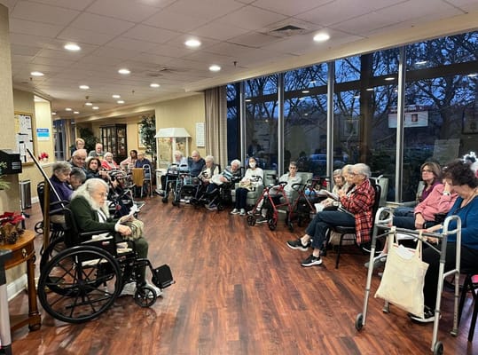 Group of residents seated in a common area of Somerset Gardens.